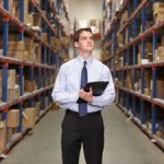 Manager In Warehouse With Clipboard