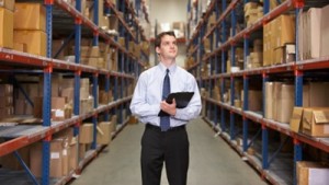 Manager In Warehouse With Clipboard